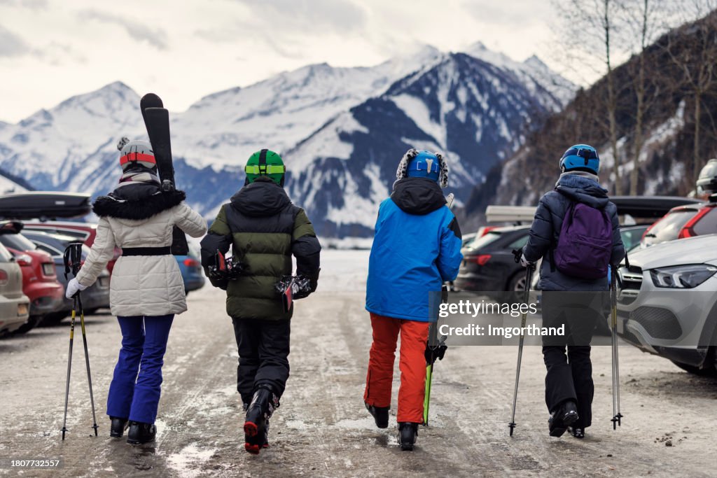 Family returning to car after skiing in European Alps