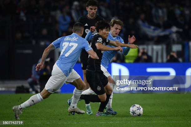 Celtic's South Korean striker Hyeon Jun Yang fights for the ball with Lazio's Montenegrin defender Adam Marusic and Lazio's Italian midfielder Nicolo...