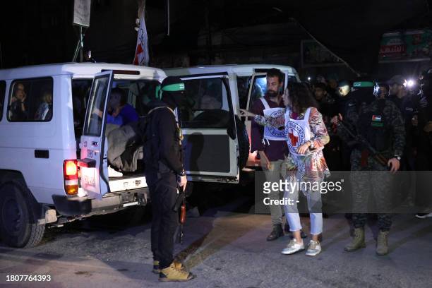 Members of the Red Cross prepare to transport hostages released by Hamas in Rafah, in the southern Gaza Strip on November 28, 2023. Hamas handed over...