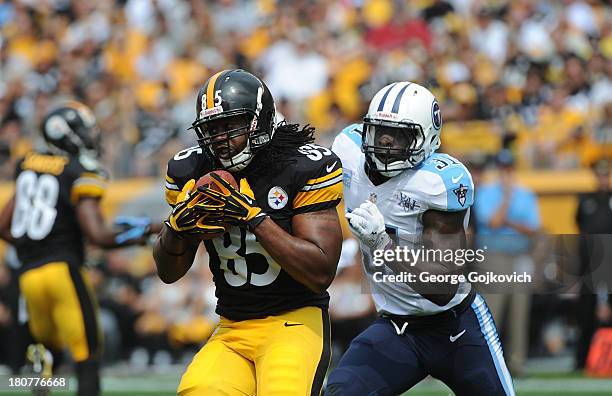 Tight end David Johnson of the Pittsburgh Steelers catches a pass against safety Bernard Pollard of the Tennessee Titans at Heinz Field on September...