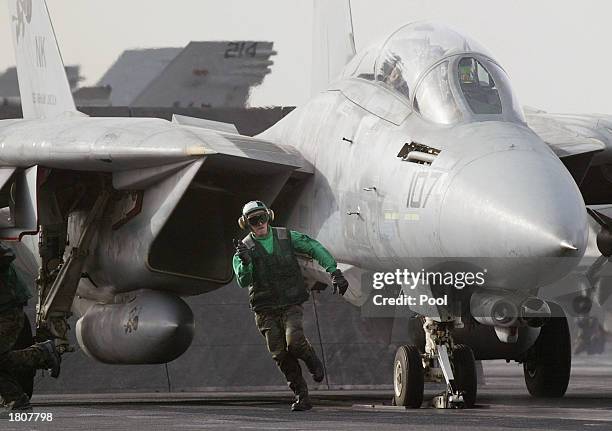 Catapult handler runs off as an F-14 Tomcat readies to be launched from the USS Abraham Lincoln aircraft carrier February 21, 2003 in the Persian...