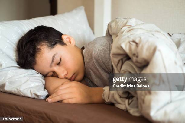 teenage boy boy sleeping in bed, selective focus - boy asleep in bed stock pictures, royalty-free photos & images