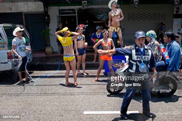 Group of Thai gay men, dance on the street in front of a massage parlor where they work, during the Songkran water festival in Pattaya city,...