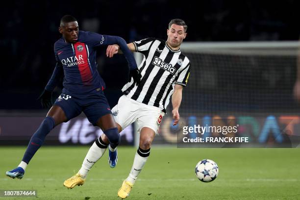 Paris Saint-Germain's French forward Randal Kolo Muani fights for the ball with Newcastle United's Swiss defender Fabian Schar during the UEFA...