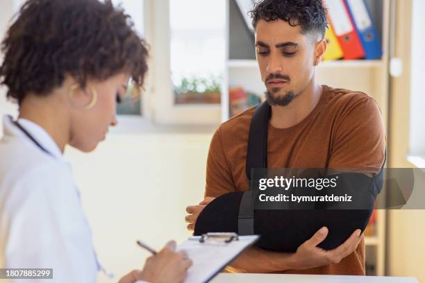 doctor at hospital prescribing treatment and talking to young patient - motor vehicle crash stock pictures, royalty-free photos & images