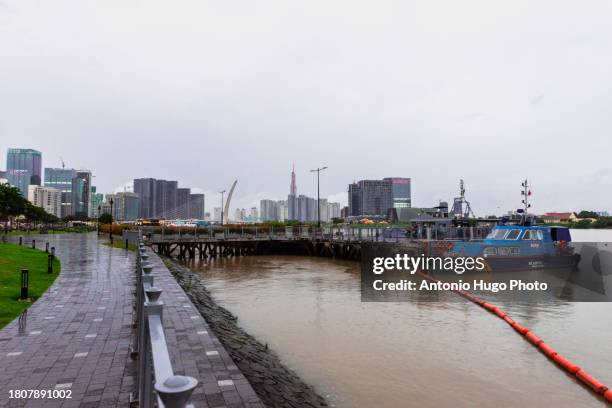 views over the financial district from a riverside park in ho chi minh city on a cloudy day. - socialism stock pictures, royalty-free photos & images