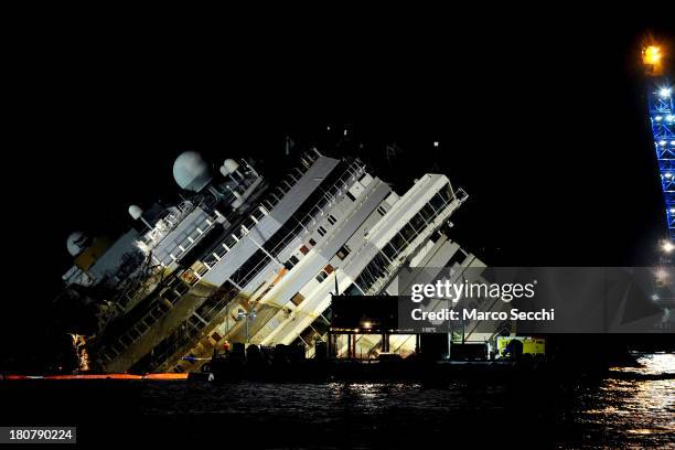 Engineers work on the wreckage of the Costa Concordia during the night as the parbuckling operation to raise the ship continues on September 16, 2013...