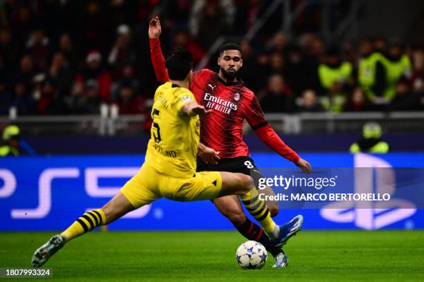 Dortmund's Algerian defender Ramy Bensebaini fights for the ball with AC Milan's English midfielder Ruben Loftus-Cheek during the UEFA Champions...