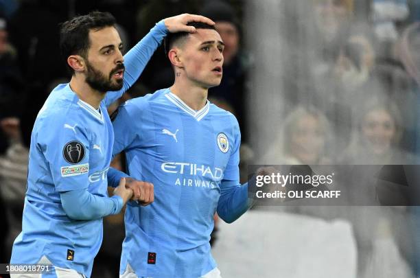 Manchester City's English midfielder Phil Foden celebrates after scoring the equalising goal with Manchester City's Portuguese midfielder Bernardo...