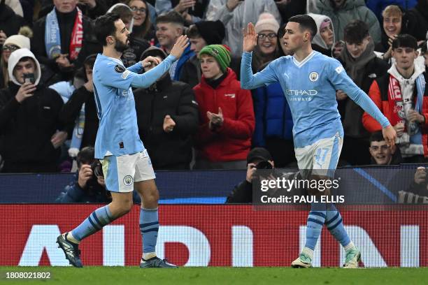 Manchester City's English midfielder Phil Foden celebrates after scoring the equalising goal with Manchester City's Portuguese midfielder Bernardo...