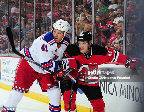 Stu Bickel of the New York Rangers grabs Harri Pesonen of the New Jersey Devils during the third period of a preseason game on September 16, 2013 at...