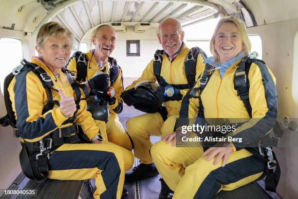 group of excited senior skydivers ready for take off - extreme sports equipment stock pictures, royalty-free photos & images