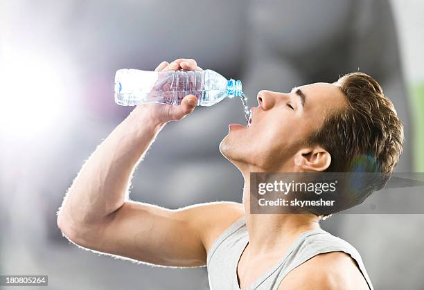 hombre joven bebiendo agua. - thirsty fotografías e imágenes de stock