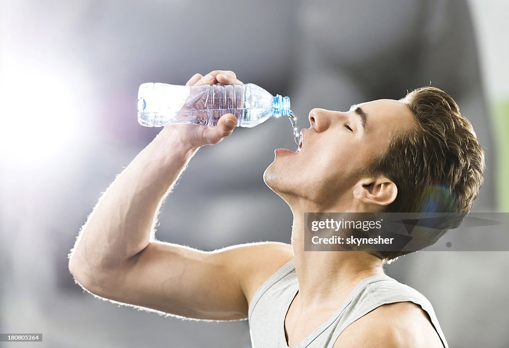 Young man drinking water.