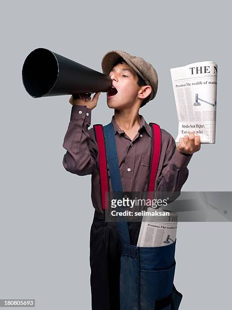 piccolo berretto newsboy con quotidiani e urlando nel megafono per vendere - topnews foto e immagini stock