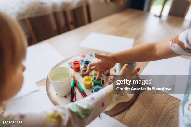 boy and girl finger painting - tiny hands stock-fotos und bilder