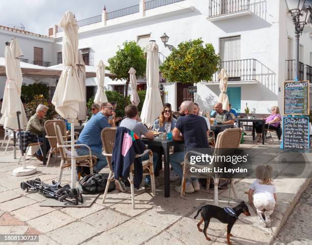 people eating, drinking and chatting on a cafe terrace in frigliana, spain - frigiliana stock pictures, royalty-free photos & images