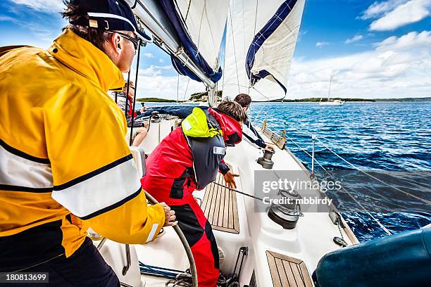 equipaggio battersi di windward navigazione in barca a vela - barca a vela foto e immagini stock