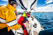 Sailing crew beating to windward on sailboat