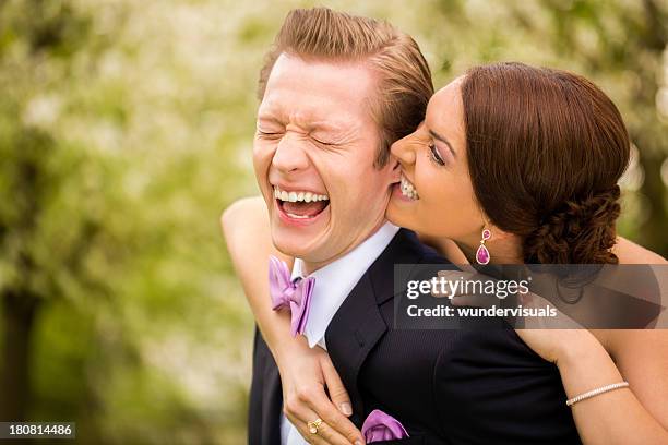 bride playfully biting groom in his earlobe - earlobe stockfoto's en -beelden