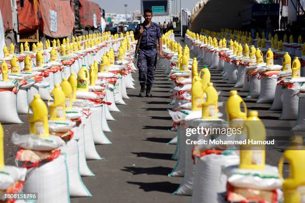 Soldier walks among food rations prepared to be distributed to families affected by over eight years of war and economic crisis at a square on...