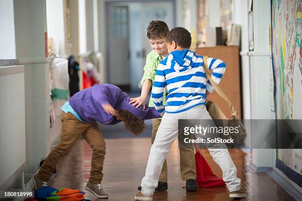 bullying in the school corridor - rough housing stock pictures, royalty-free photos & images