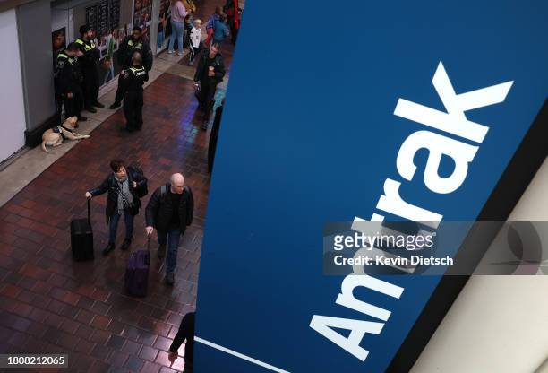 Travelers walk to board an Amtrak train at Union Station on November 22, 2023 in Washington, DC. Flights, highways, trains, and other forms of...
