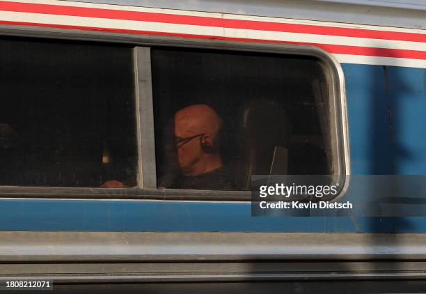 Traveler is seen inside an Amtrak train as it arrives at Union Station on November 22, 2023 in Washington, DC. Flights, highways, trains, and other...