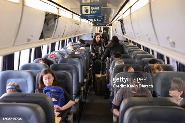 Travelers board an Amtrak train at Union Station on November 22, 2023 in Washington, DC. Flights, highways, trains, and other forms of transportation...