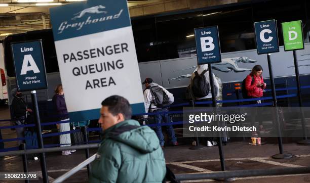 Travelers wait to board Greyhound buses at Union Station on November 22, 2023 in Washington, DC. Flights, highways, trains, and other forms of...