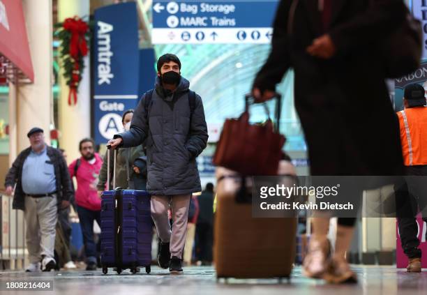 Travelers walk through Union Station on November 22, 2023 in Washington, DC. Flights, highways, trains, and other forms of transportation are...