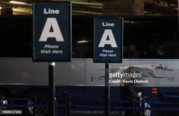 Traveler waits to board a Greyhound bus at Union Station on November 22, 2023 in Washington, DC. Flights, highways, trains, and other forms of...
