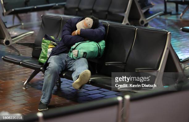 Traveler rests on a bench as they wait in Union Station on November 22, 2023 in Washington, DC. Flights, highways, trains, and other forms of...