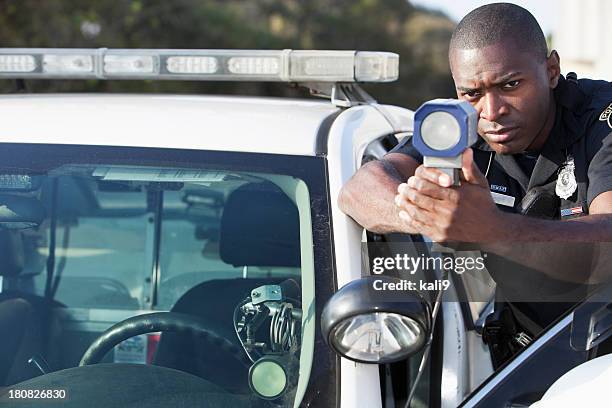 police officer with radar gun - lasergun stockfoto's en -beelden