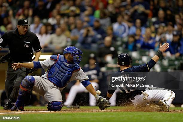 Caleb Gindl of the Milwaukee Brewers beats the tag by Welington Castillo of the Chicago Cubs while reaching home plate on a double hit by Yuniesky...