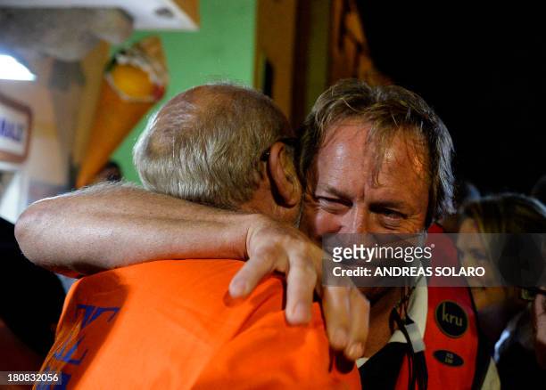 South African Nick Sloan , senior salvage master of Titan-Micoperi, embraces a worker following the rotation of the wreck of Italy's Costa Concordia...