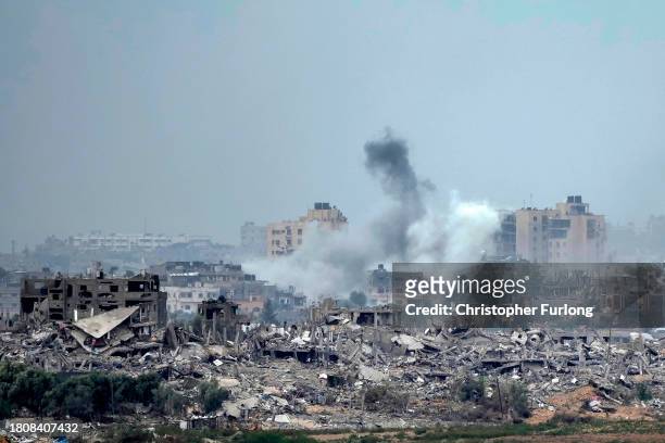 In this photograph taken near the Israeli border with the Gaza Strip, a plume of smoke rises over Beit Hanoun in Northern Gaza after an Israeli air...