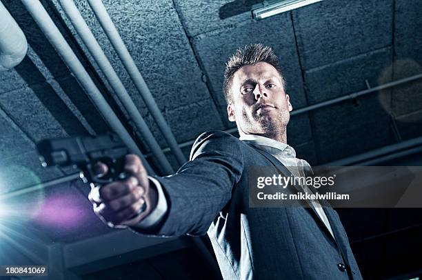 contract killer points gun at someone - gun barrel stock pictures, royalty-free photos & images