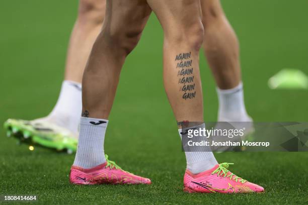 Tattoo reading Again and repeating until fading to reading Gain on the lower limb of Mykhailo Mudryk of Ukraine during the warm up prior to the UEFA...