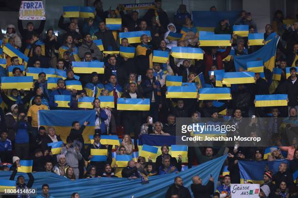 Ukraine fans hold aloft flags prior to kick off in the UEFA EURO 2024 European qualifier match between Ukraine and Italy at BayArena on November 20,...