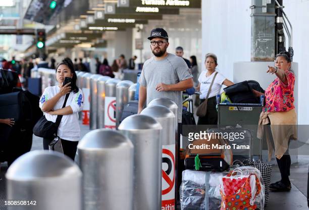 Travelers await vehicles at Los Angeles International Airport ahead of the Thanksgiving holiday on November 22, 2023 in Los Angeles, California. AAA...