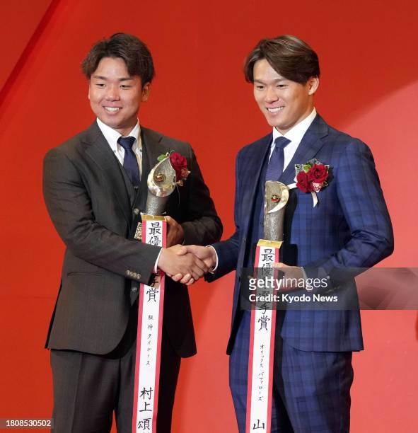 Orix Buffaloes pitcher Yoshinobu Yamamoto and Hanshin Tigers pitcher Shoki Murakami shake hands after winning Japanese pro baseball's MVP awards in...