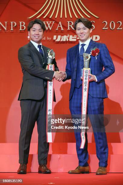 Orix Buffaloes pitcher Yoshinobu Yamamoto and Hanshin Tigers pitcher Shoki Murakami shake hands after winning Japanese pro baseball's MVP awards in...