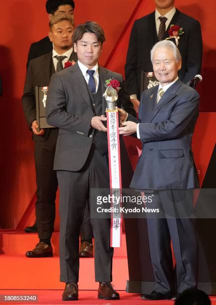 Hanshin Tigers pitcher Shoki Murakami receives Japanese pro baseball's Central League MVP award at a ceremony in Tokyo on Nov. 28, 2023.