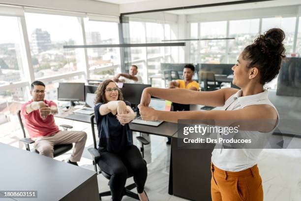 trabajadores haciendo ejercicio en la oficina - estirándose fotografías e imágenes de stock