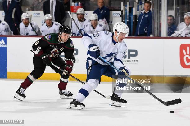 Michael Eyssimont of the Tampa Bay Lightning skates with the puck while being defended by Clayton Keller of the Arizona Coyotes during the first...