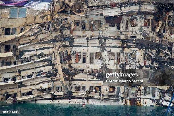 The severely damaged side of the stricken Costa Concordia is visible after the parbuckling operation succesfully uprighted the ship around 4 am on...