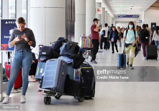 Travelers gather in the Delta terminal at Los Angeles International Airport ahead of the Thanksgiving holiday on November 22, 2023 in Los Angeles,...
