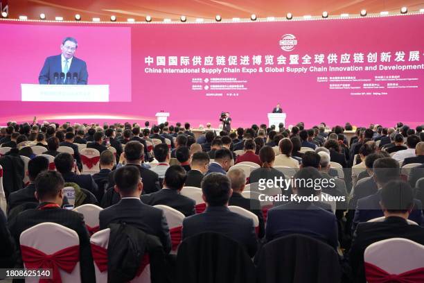 Chinese Premier Li Qiang is projected on the screen during the opening ceremony of the first China International Supply Chain Expo in Beijing on Nov....