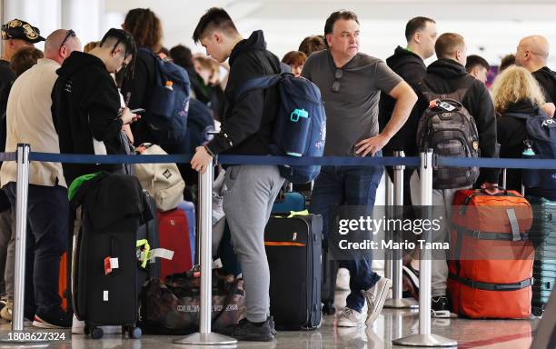 Travelers wait in the line to check in for flights at Los Angeles International Airport ahead of the Thanksgiving holiday on November 22, 2023 in Los...